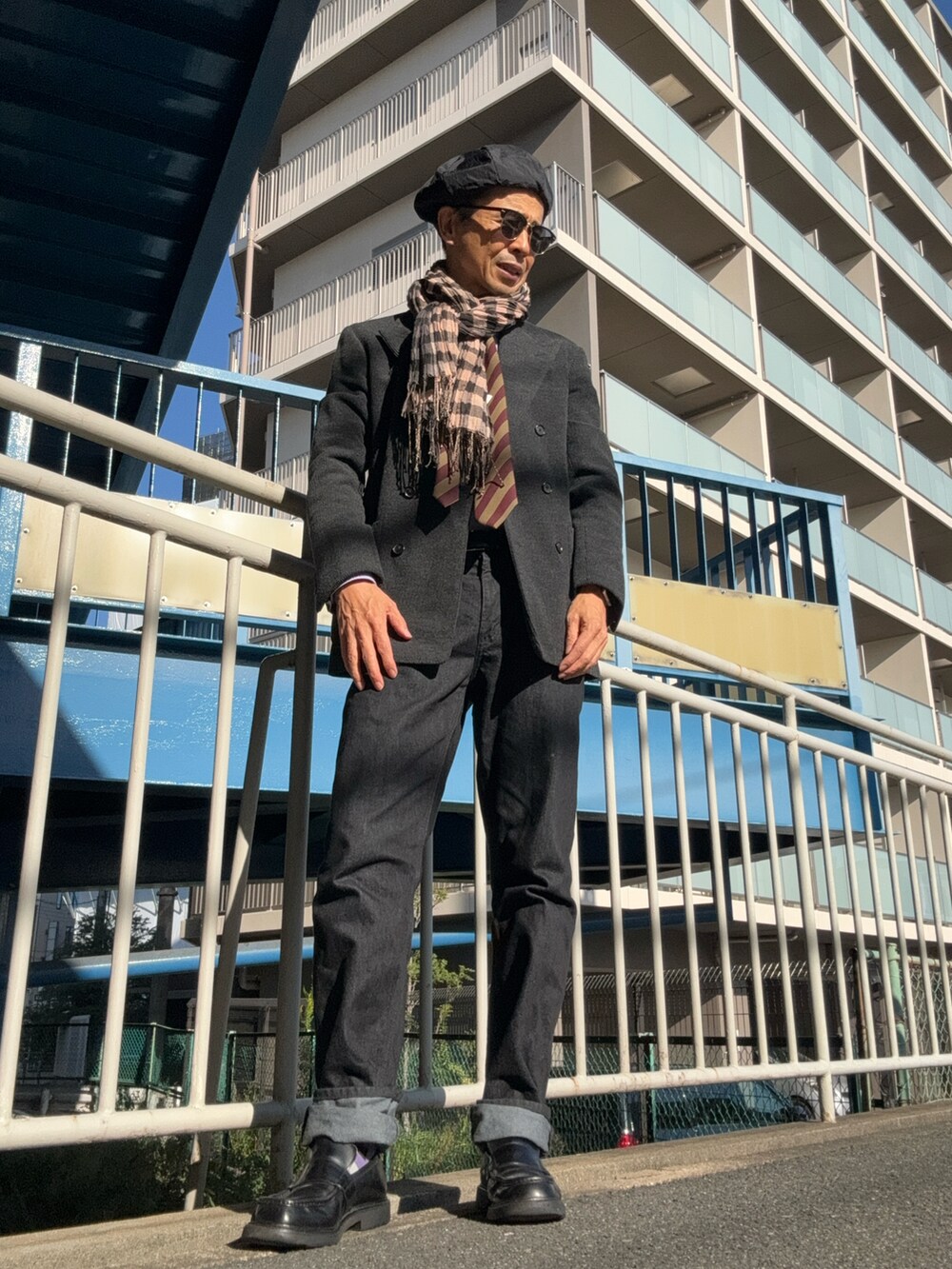 ブラック系のデニムパンツ、ブラック系のローファー、グレー系のテーラードジャケットを着用したメンズの秋コーディネートの2枚目の写真