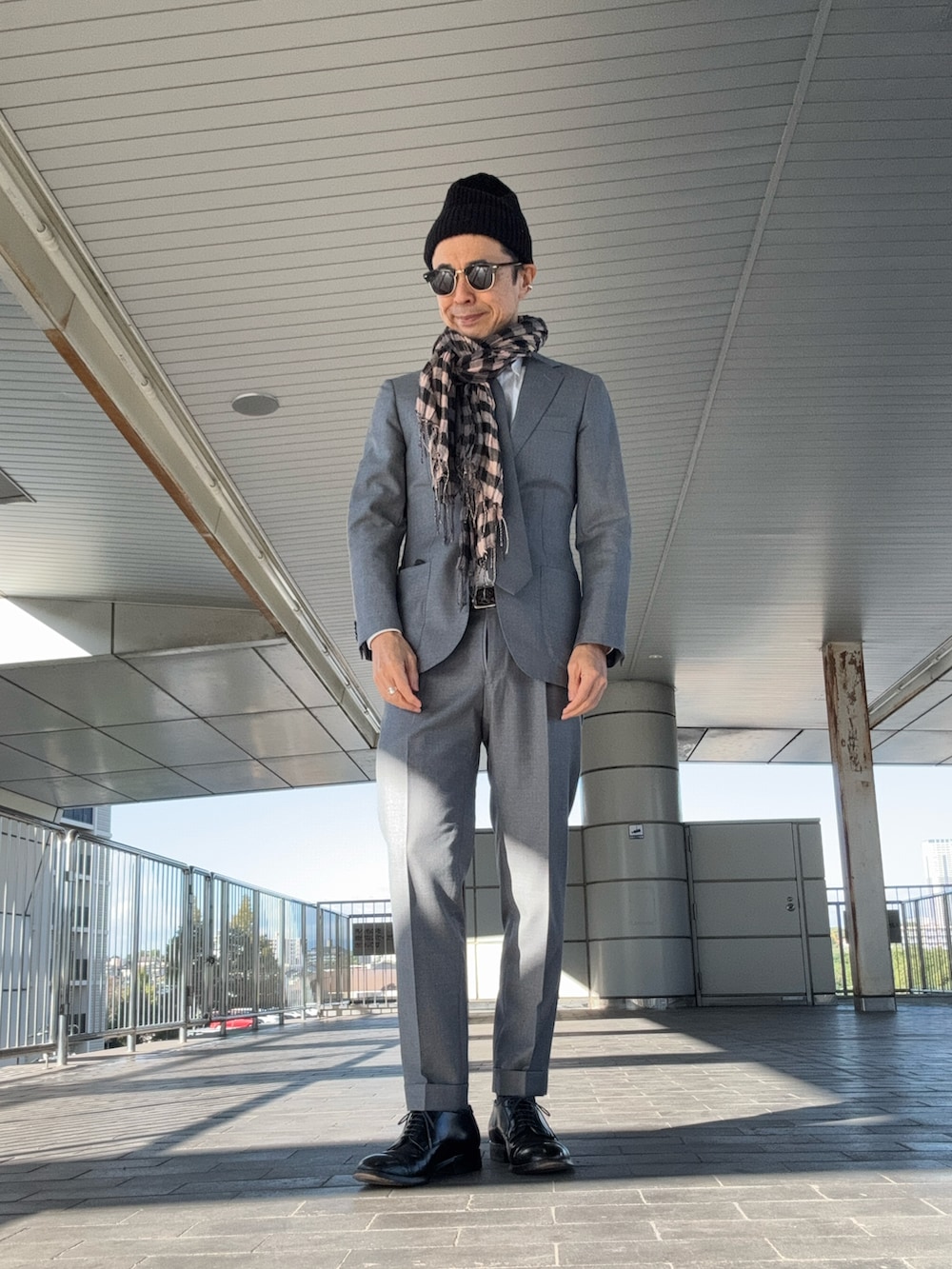 グレー系のスーツセット、ブラック系のドレスシューズ、グレー系のネクタイを着用したメンズの秋コーディネートの2枚目の写真