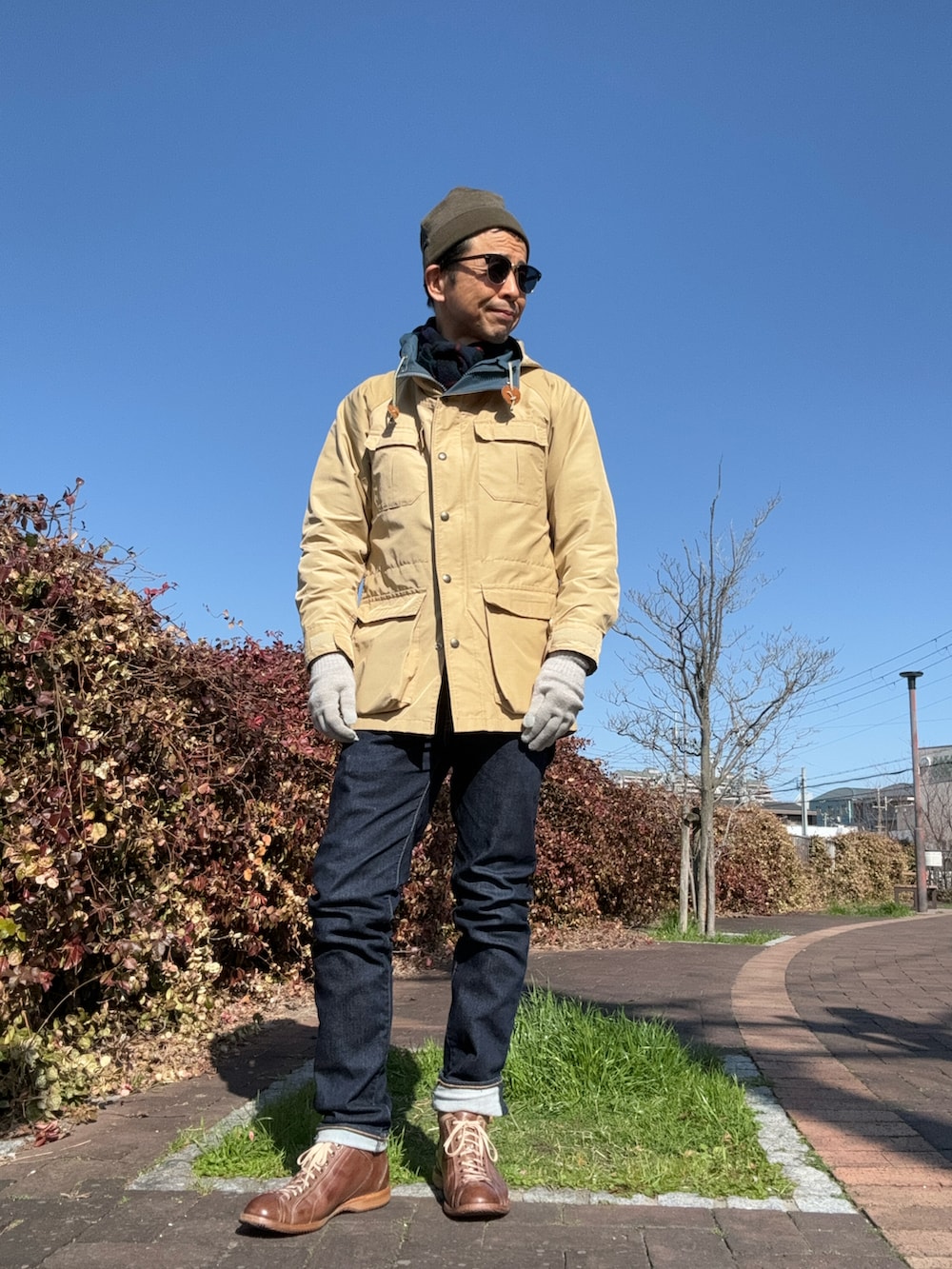 ブルー系のデニムパンツ、ブラウン系のスニーカー、ブラウン系のニット/セーターを着用したメンズの冬コーディネートの2枚目の写真