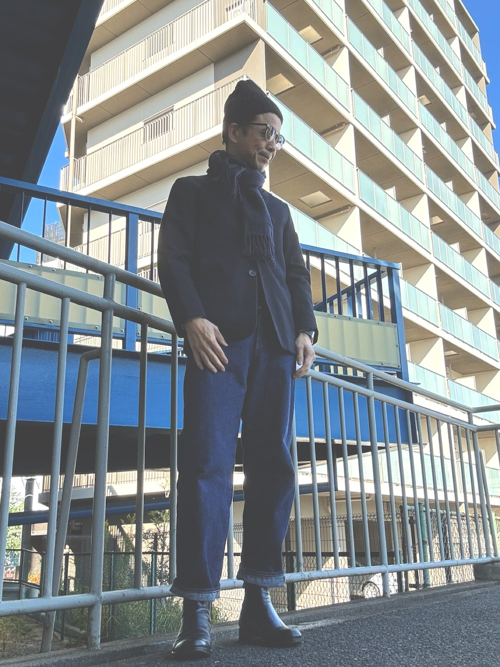 ブルー系のデニムパンツ、ブルー系のネクタイ、ブラック系のブーツを着用したメンズの冬コーディネートの2枚目の写真