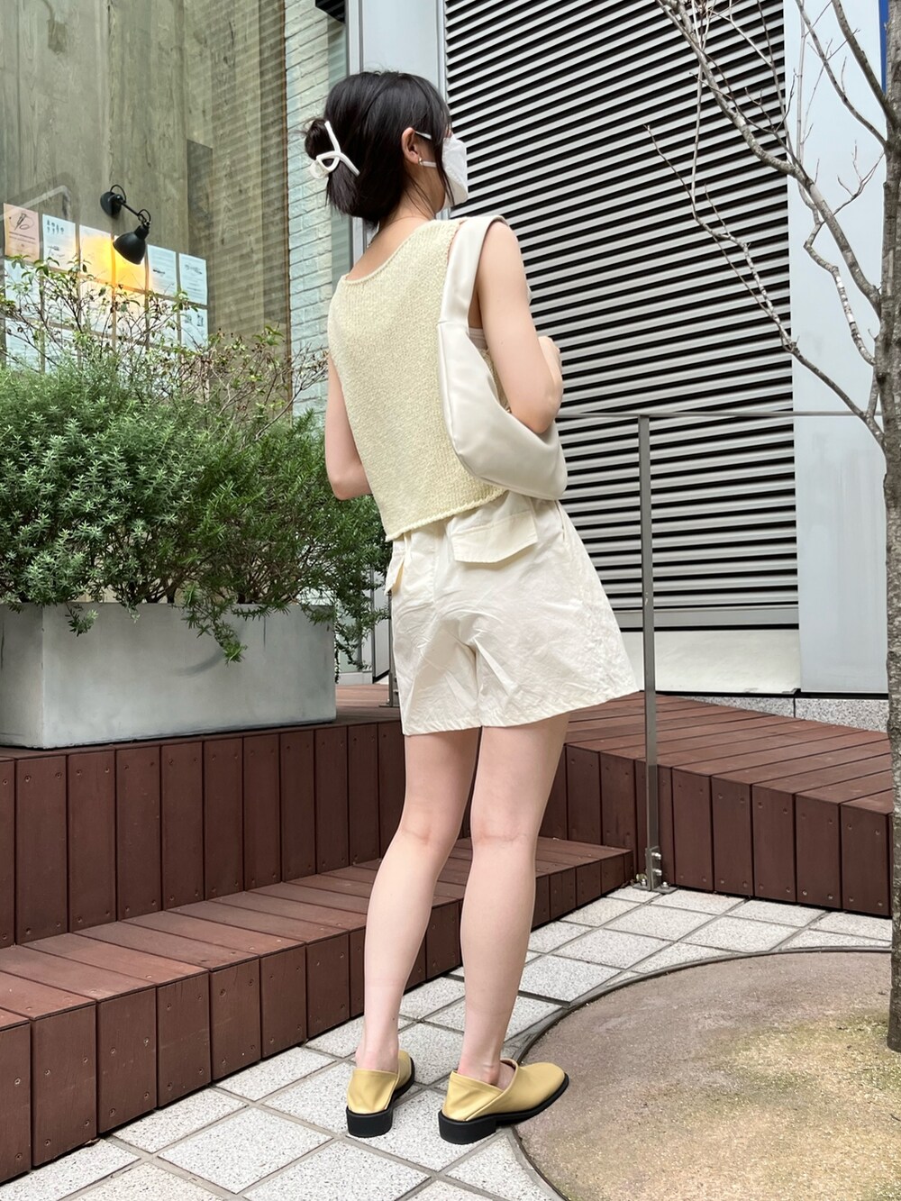 イエロー系のベスト、ベージュ系のその他パンツ、ベージュ系のローファーを着用したレディースの夏コーディネートの2枚目の写真