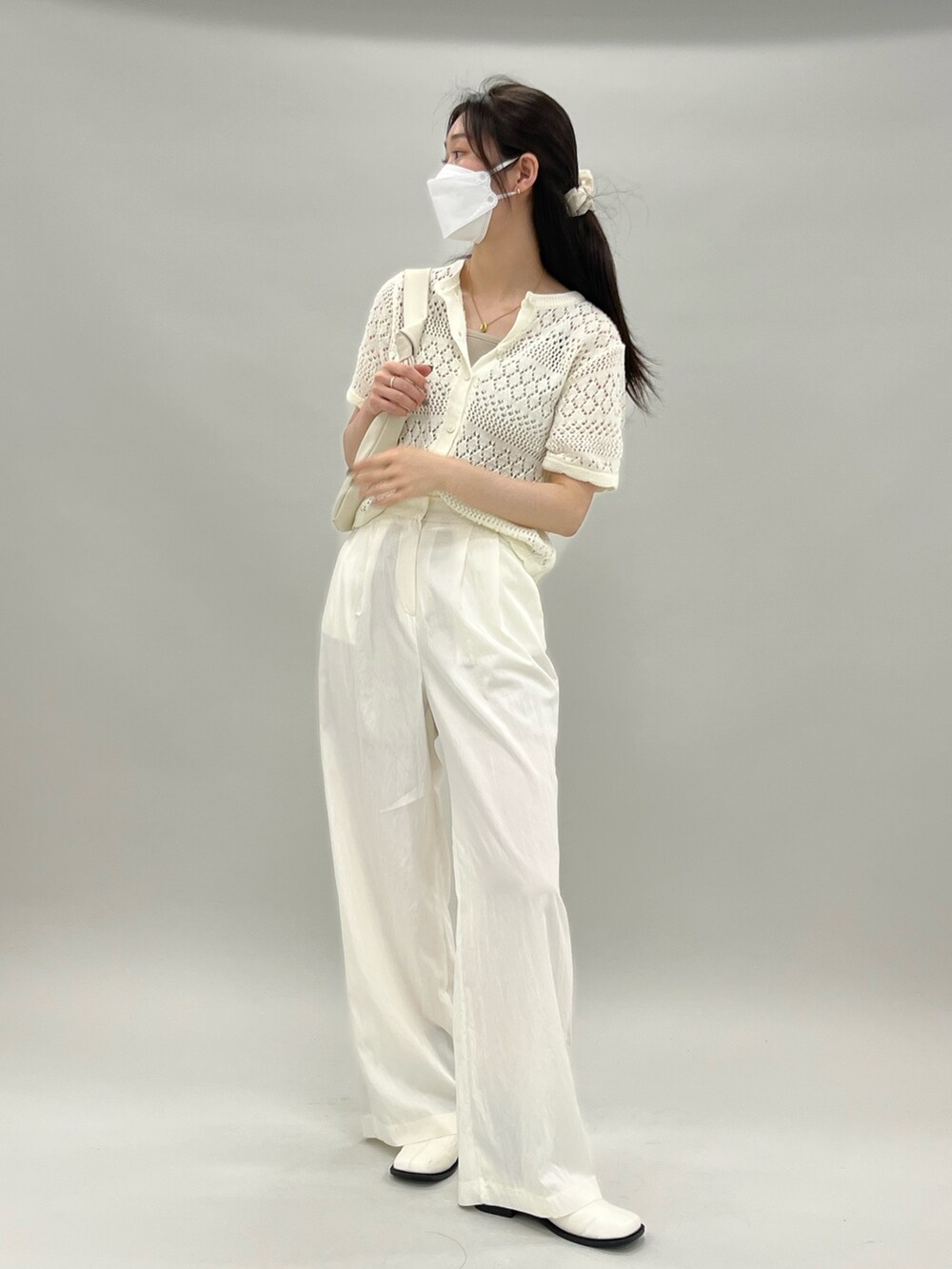 ベージュ系のカーディガン/ボレロ、ベージュ系のキャミソール、ベージュ系のスラックスを着用したレディースの夏コーディネートの2枚目の写真