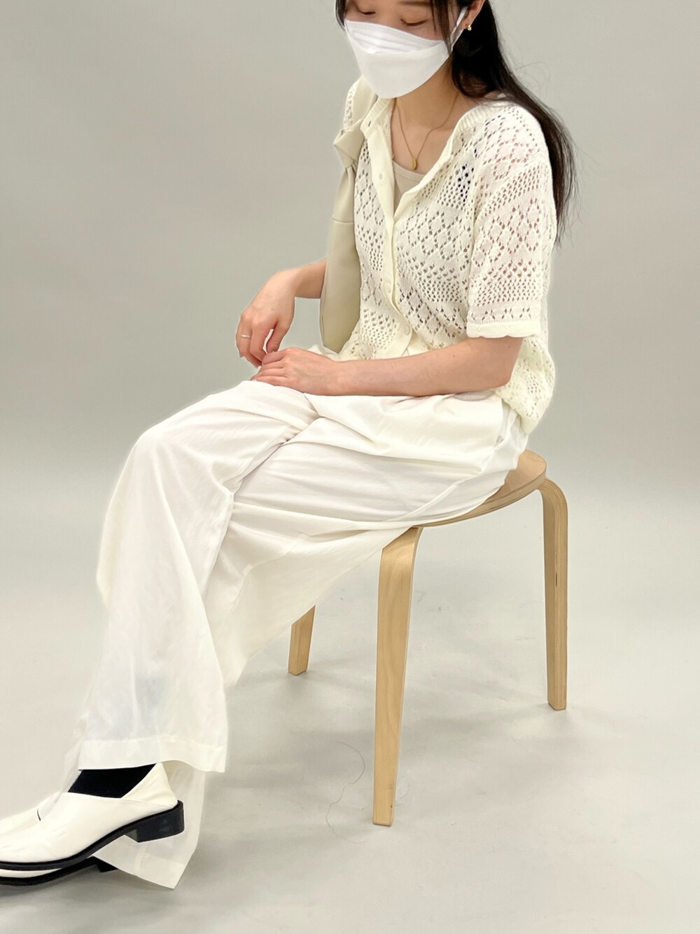 ベージュ系のカーディガン/ボレロ、ベージュ系のキャミソール、ベージュ系のスラックスを着用したレディースの夏コーディネートの3枚目の写真