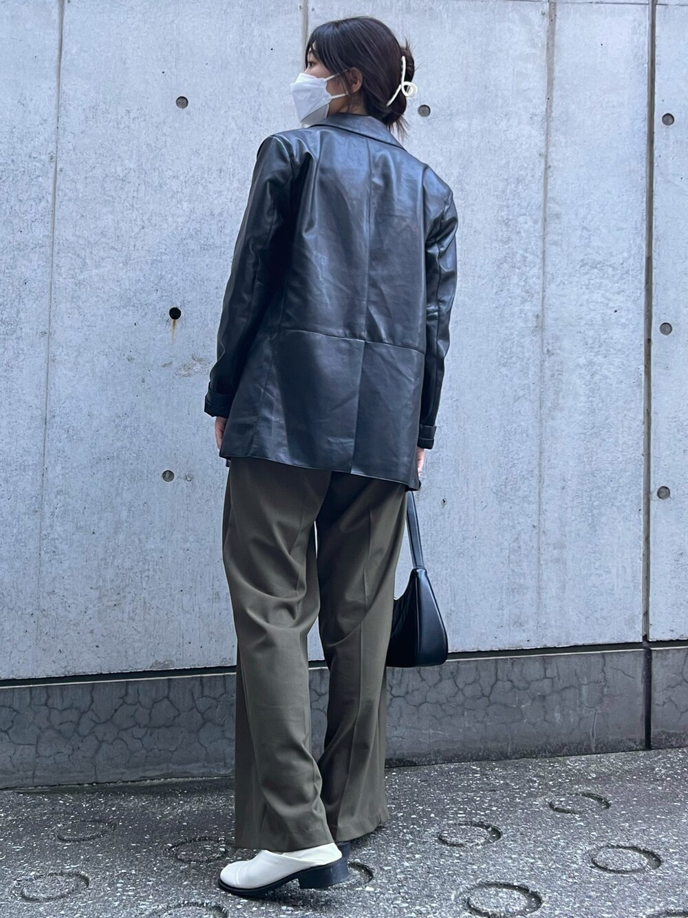 グリーン系のスラックス、ベージュ系のベスト、ホワイト系のシューズを着用したレディースの秋コーディネートの2枚目の写真