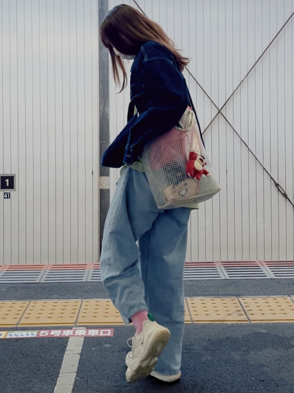 ブルー系のデニムパンツ、ホワイト系のスニーカー、ブルー系のワンピースを着用したレディースの春コーディネートの2枚目の写真