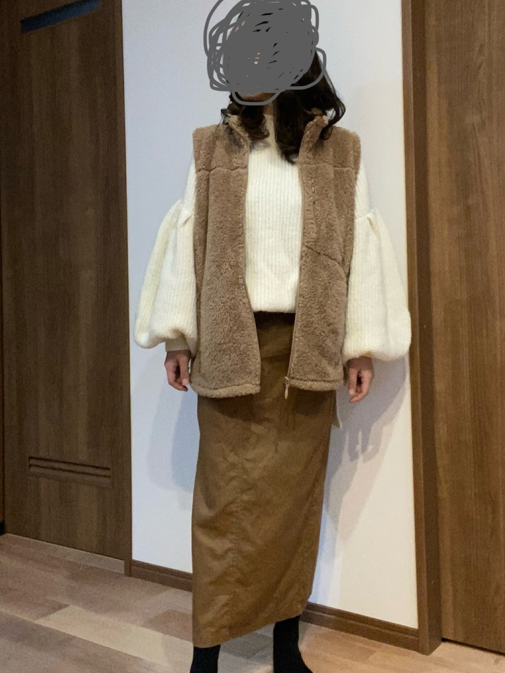 ブラウン系のスカート、ホワイト系のニット/セーターを着用したレディースの冬コーディネートの2枚目の写真