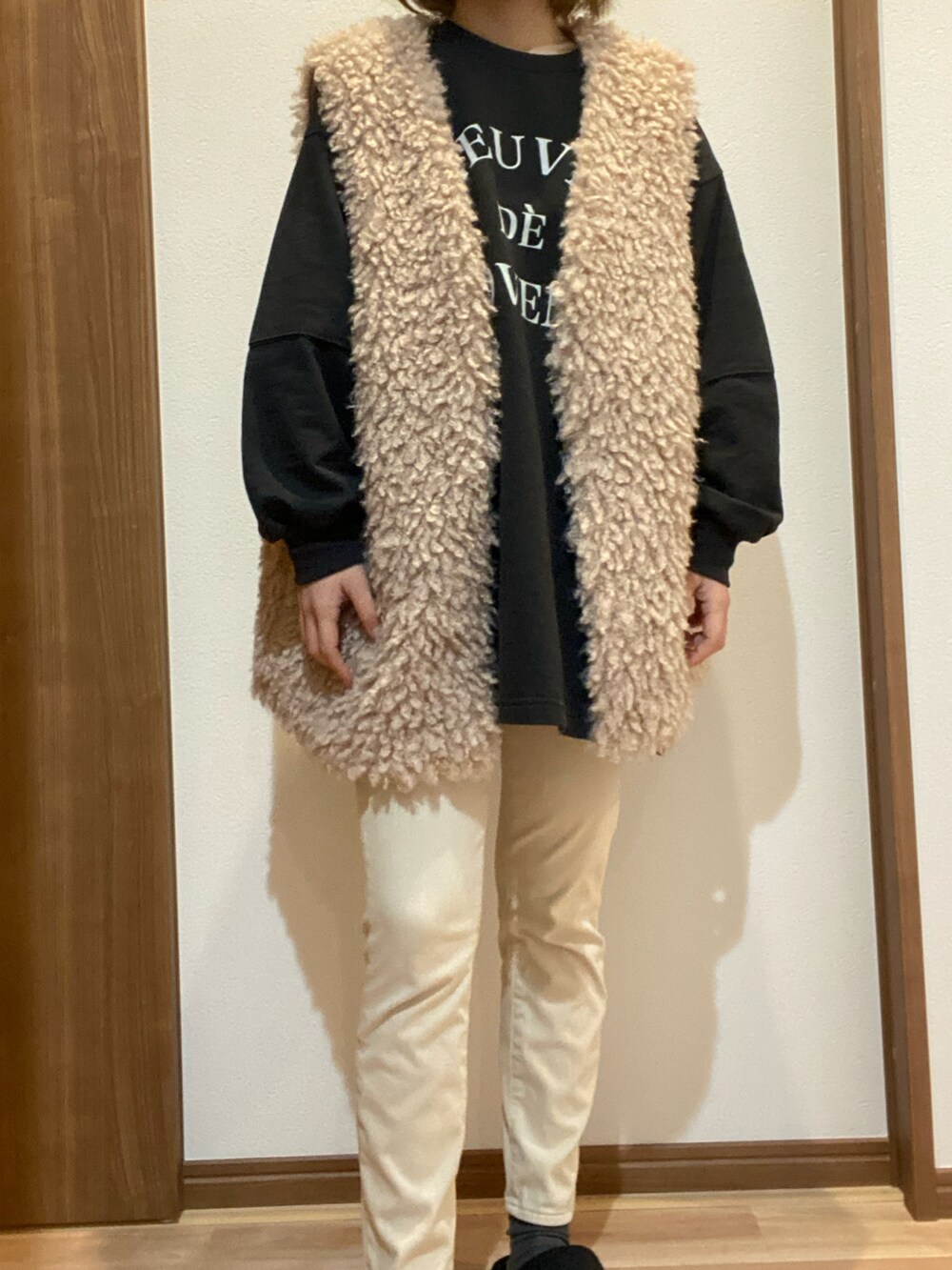 ベージュ系のベストを着用したレディースの春コーディネートの2枚目の写真