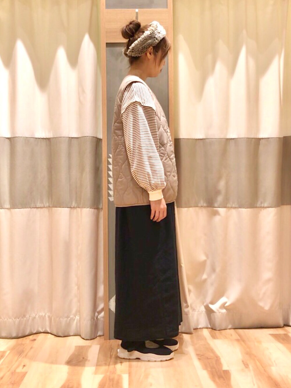 ブラウン系のTシャツ/カットソー、ブラック系のワンピース、ブラック系のスニーカーを着用したレディースの秋コーディネートの2枚目の写真