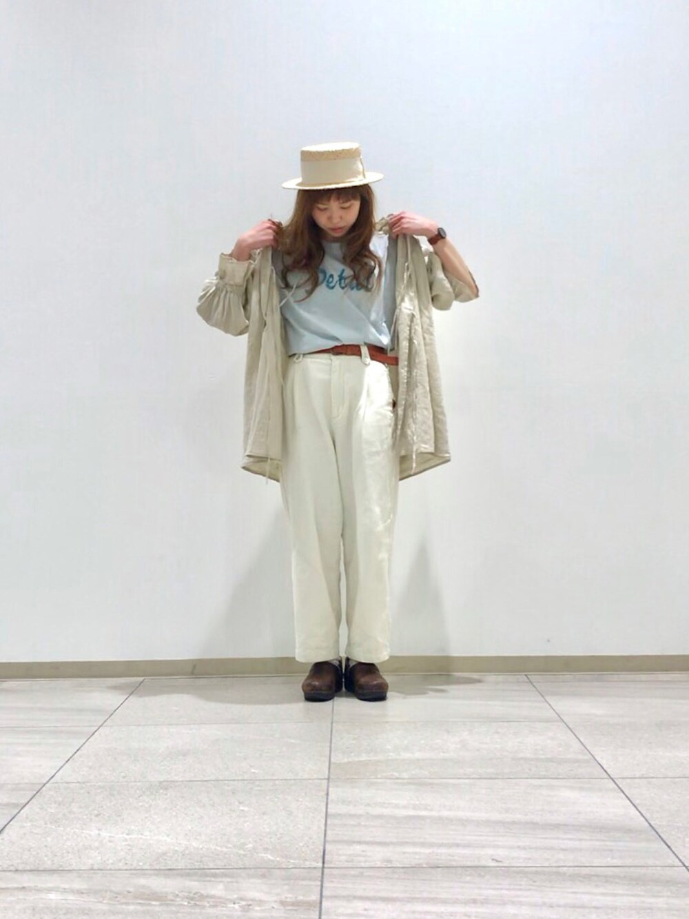 ホワイト系のチュニック、ホワイト系のデニムパンツ、ブルー系のTシャツ/カットソーを着用したレディースの春コーディネートの2枚目の写真