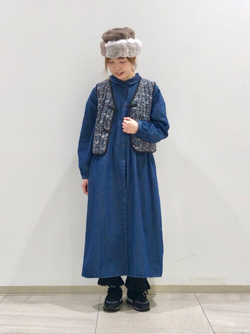 グレー系のベスト、ブルー系のワンピース、ブラック系のその他パンツを着用したレディースの冬コーディネートの4枚目の写真