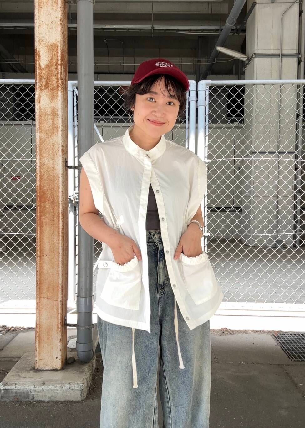 ブルー系のデニムパンツ、ブラック系のスニーカー、ホワイト系のその他アウターを着用したレディースの夏コーディネートの2枚目の写真