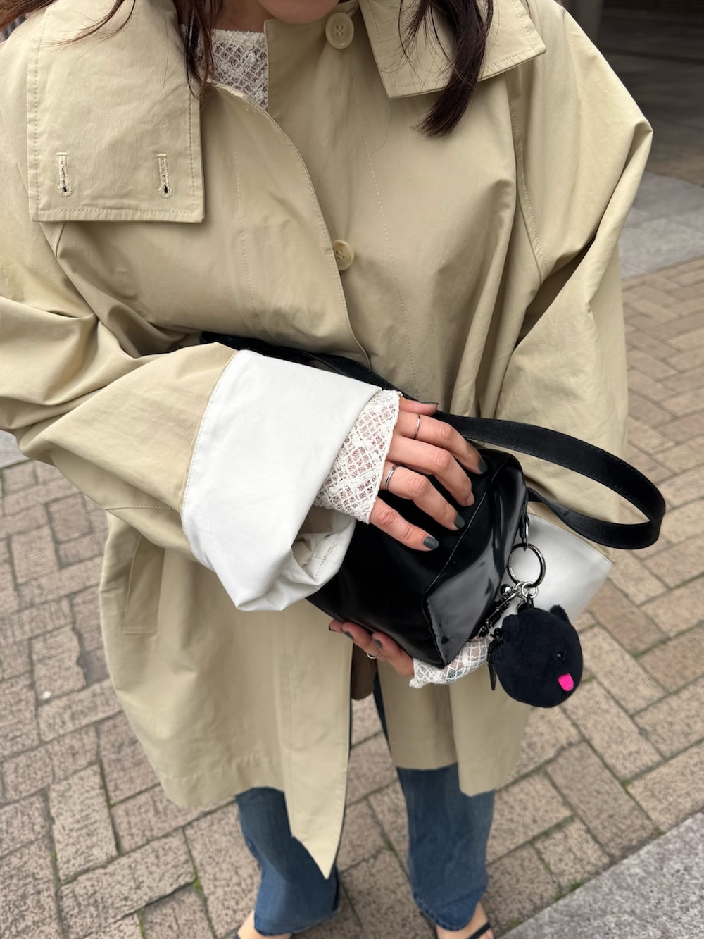 ブラック系のトートバッグ、ベージュ系のその他アウターを着用したレディースの春コーディネートの5枚目の写真