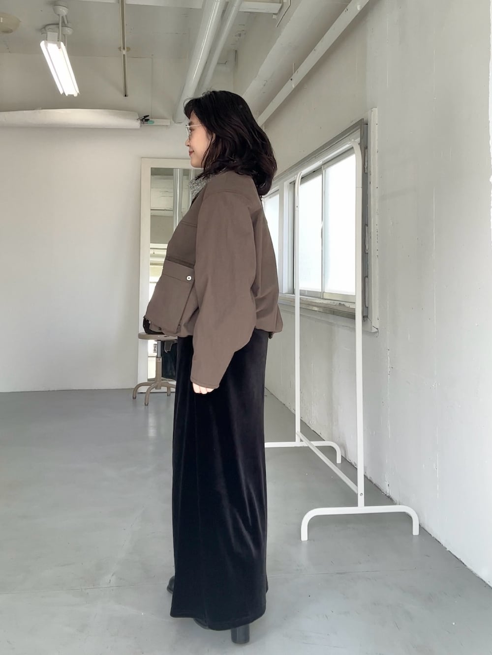 ブラウン系のブルゾン、ブラック系のスカート、ブラック系のスカートを着用したレディースの冬コーディネートの2枚目の写真