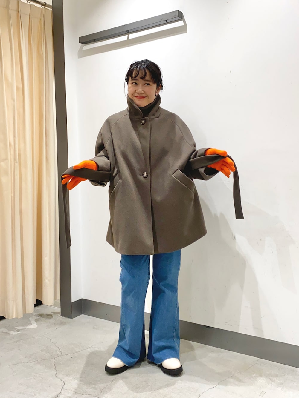 ブラウン系のピーコート、ホワイト系のブーツを着用したレディースの冬コーディネートの3枚目の写真