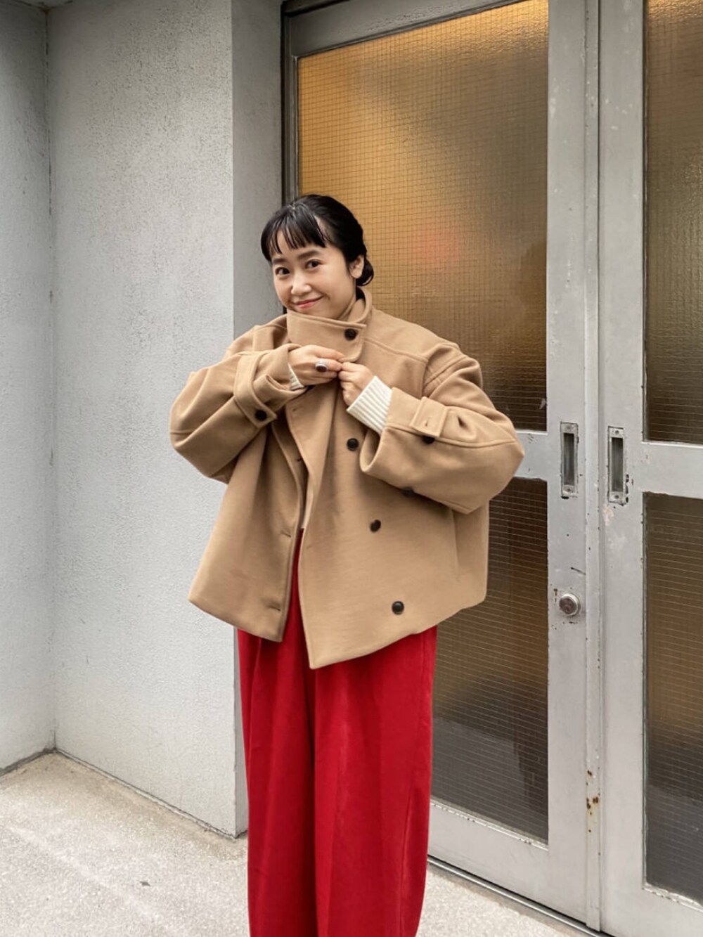 イエロー系のその他アウター、レッド系のその他パンツ、ベージュ系のブーツを着用したレディースの冬コーディネートの3枚目の写真