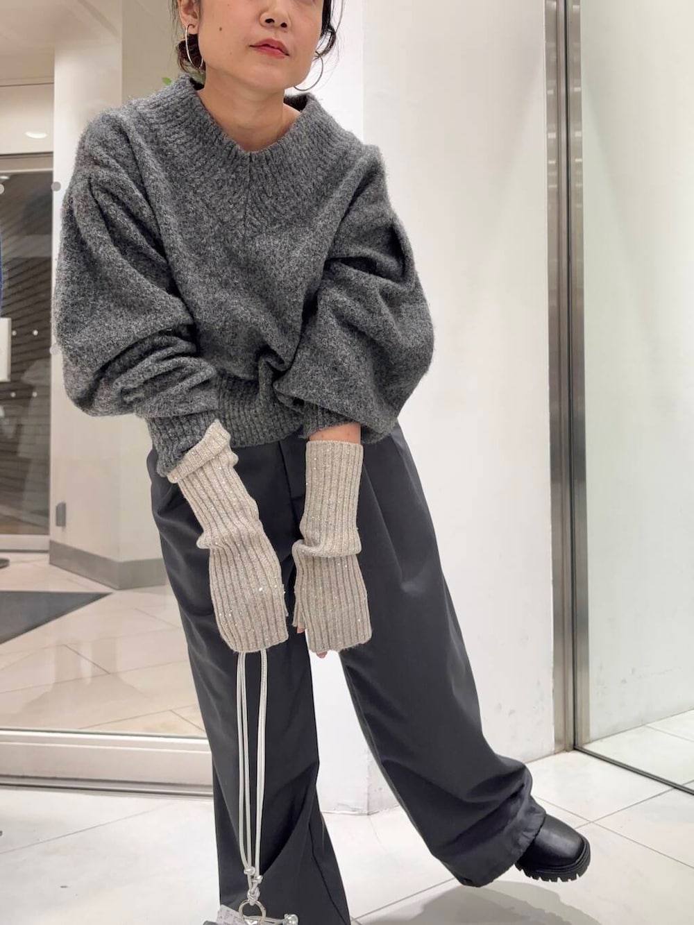 ブラック系のブーツ、グレー系のスラックス、グレー系のニット/セーターを着用したレディースの冬コーディネートの2枚目の写真