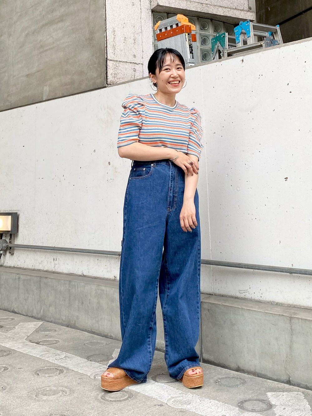 ブラウン系のサンダル、ブルー系のデニムパンツ、ブラウン系のTシャツ/カットソーを着用したレディースの夏コーディネートの3枚目の写真