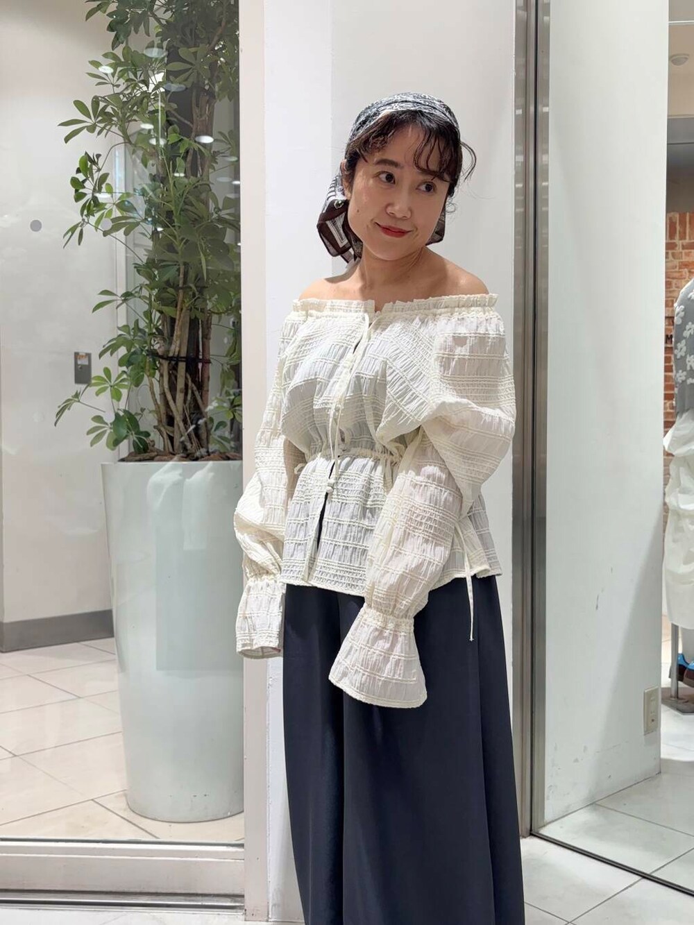 グレー系のその他パンツ、ホワイト系のシャツ/ブラウス、ブラウン系のスニーカーを着用したレディースの冬コーディネートの2枚目の写真