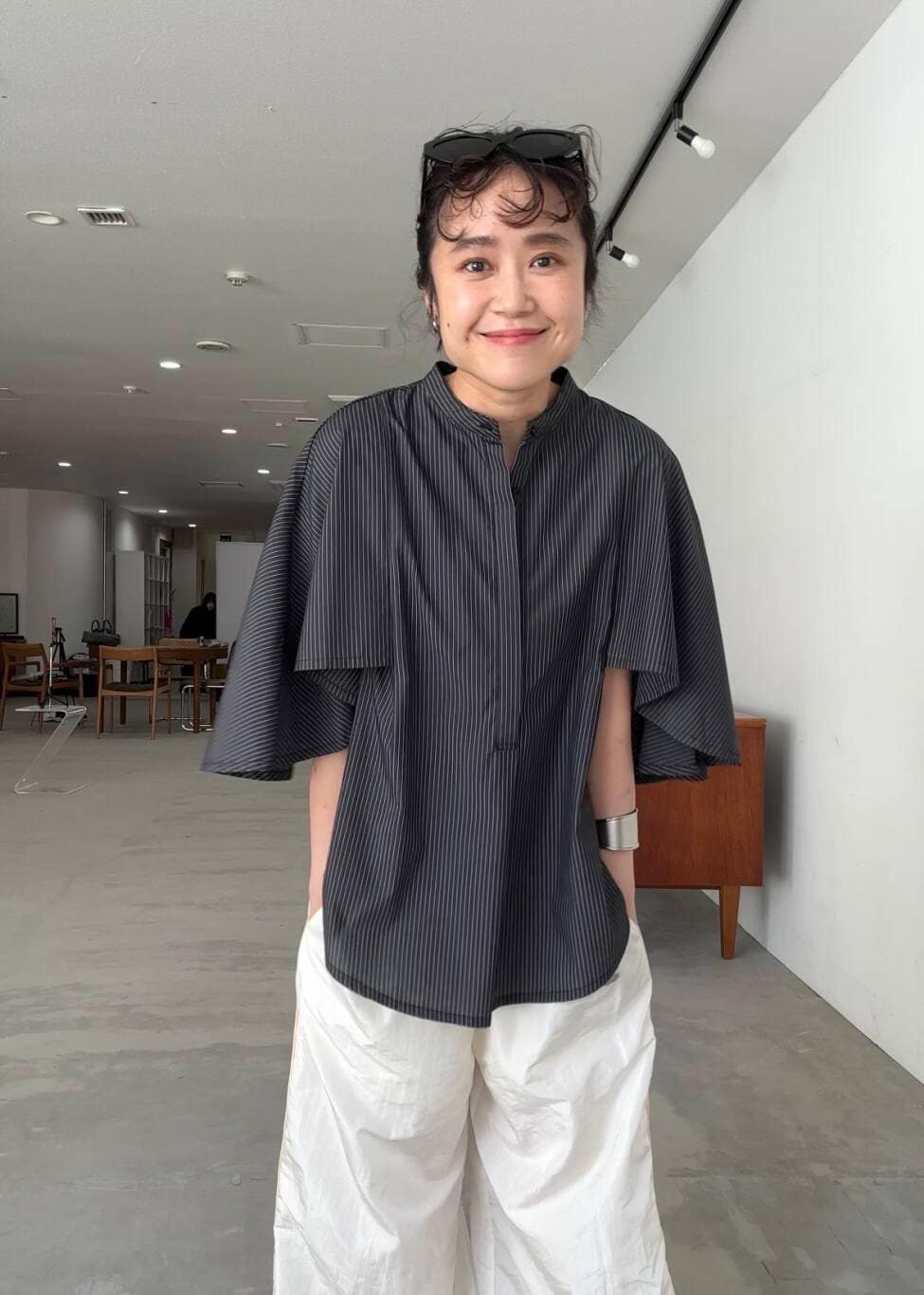 ホワイト系のその他パンツ、グレー系のシャツ/ブラウス、ブラック系のスニーカーを着用したレディースの夏コーディネートの2枚目の写真