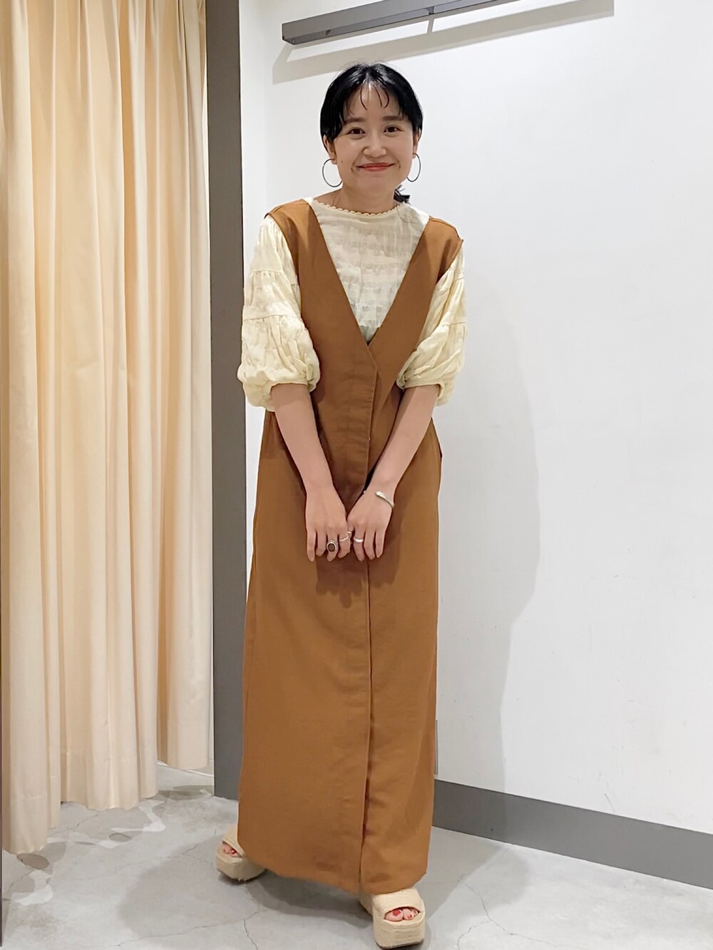 ブラウン系のワンピース、ベージュ系のシューズ、ホワイト系のシャツ/ブラウスを着用したレディースの夏コーディネートの2枚目の写真