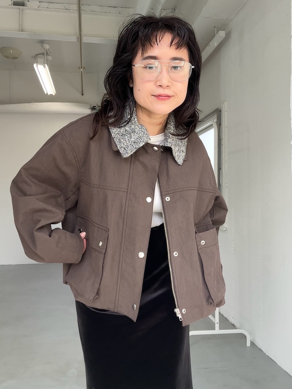 ブラウン系のブルゾン、ブラック系のスカート、ブラック系のスカートを着用したレディースの冬コーディネートの3枚目の写真