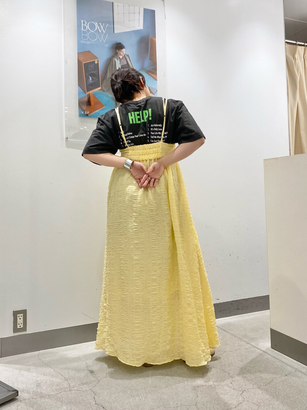 イエロー系のワンピースを着用したレディースの春コーディネートの2枚目の写真