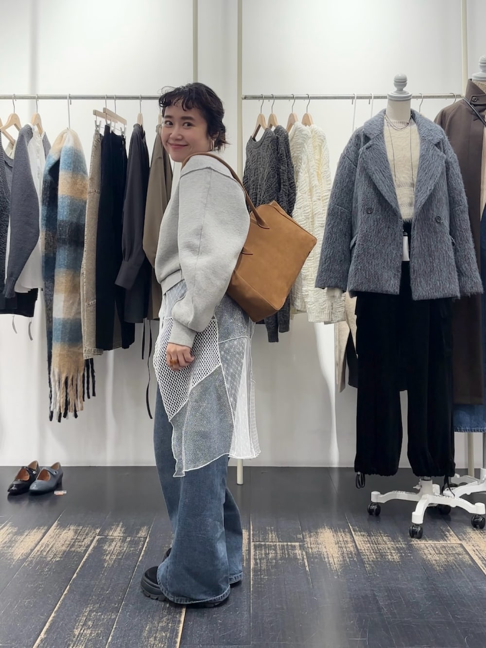 グリーン系のニット/セーター、グレー系のニット/セーター、イエロー系のボストンバッグを着用したレディースの冬コーディネートの2枚目の写真