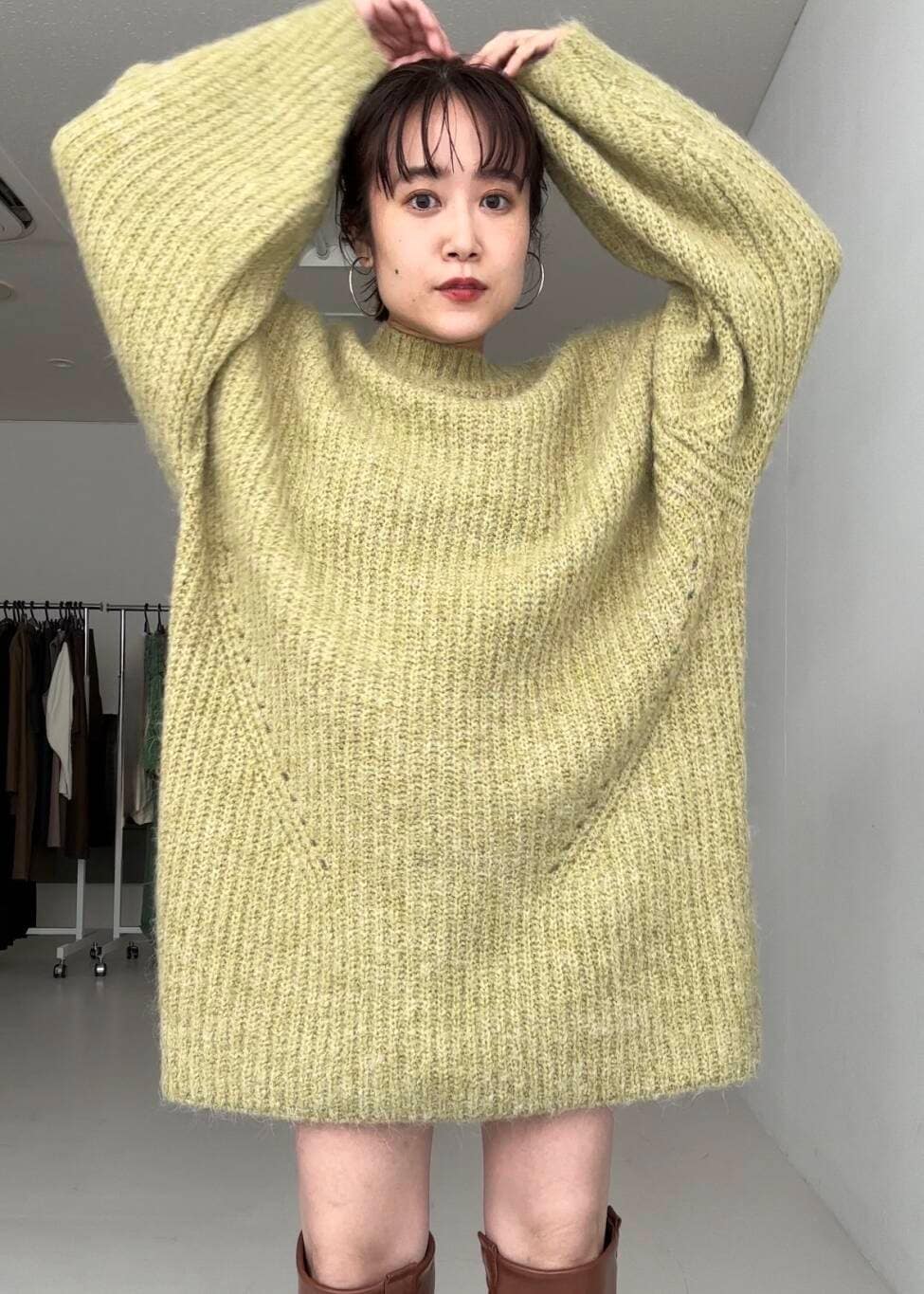 グリーン系のワンピース、ブラウン系のブーツを着用したレディースの秋コーディネートの4枚目の写真