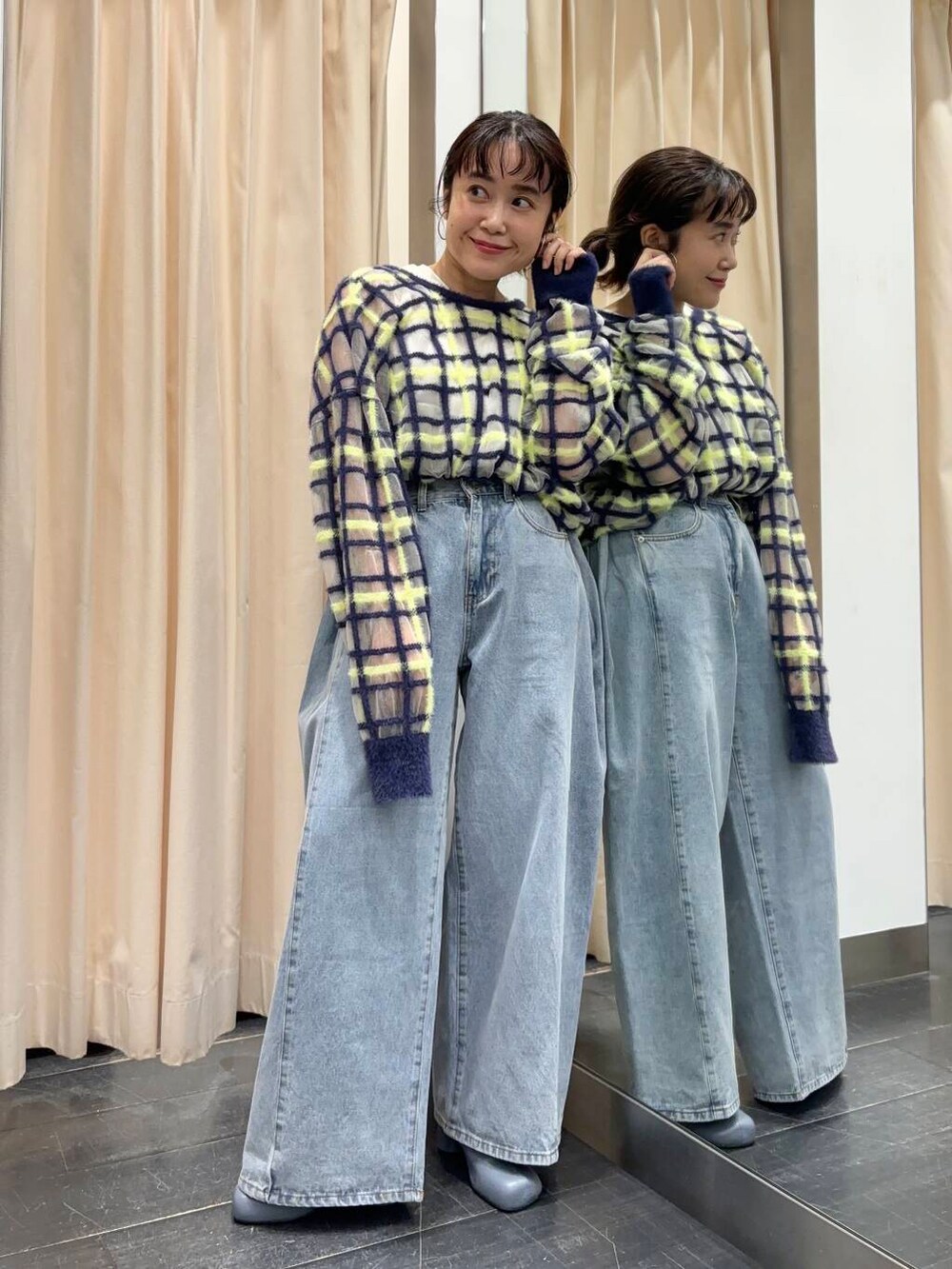 ブルー系のニット/セーター、ブルー系のデニムパンツ、グレー系のブーツを着用したレディースの夏コーディネートの3枚目の写真