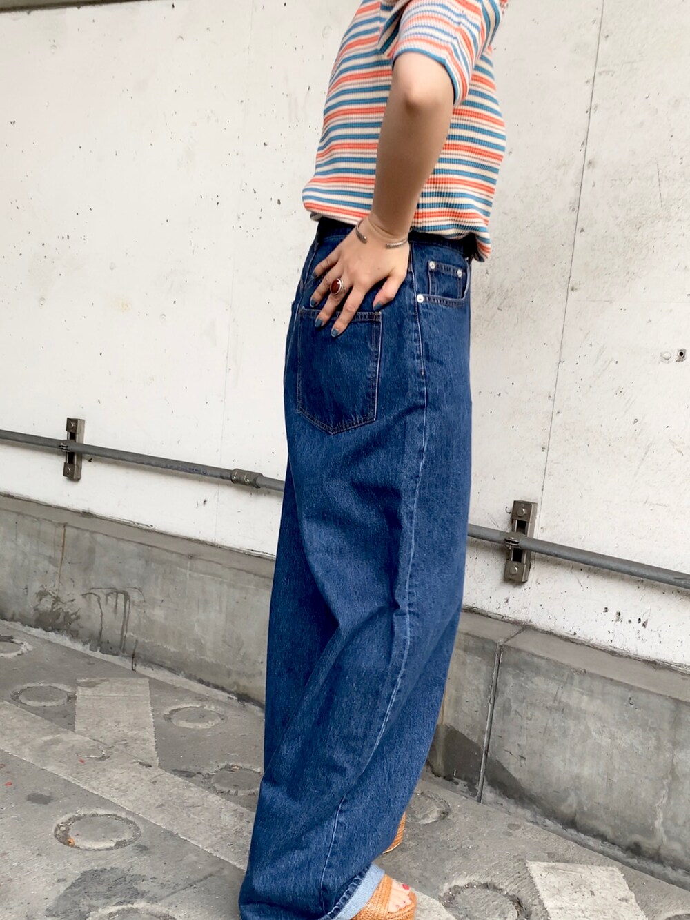 ブラウン系のサンダル、ブルー系のデニムパンツ、ブラウン系のTシャツ/カットソーを着用したレディースの夏コーディネートの2枚目の写真