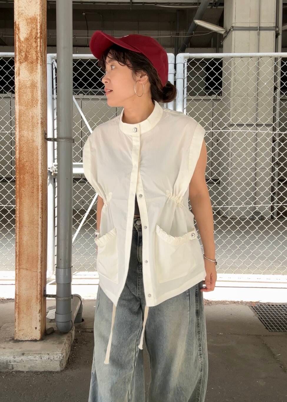 ブルー系のデニムパンツ、ブラック系のスニーカー、ホワイト系のその他アウターを着用したレディースの夏コーディネートの4枚目の写真