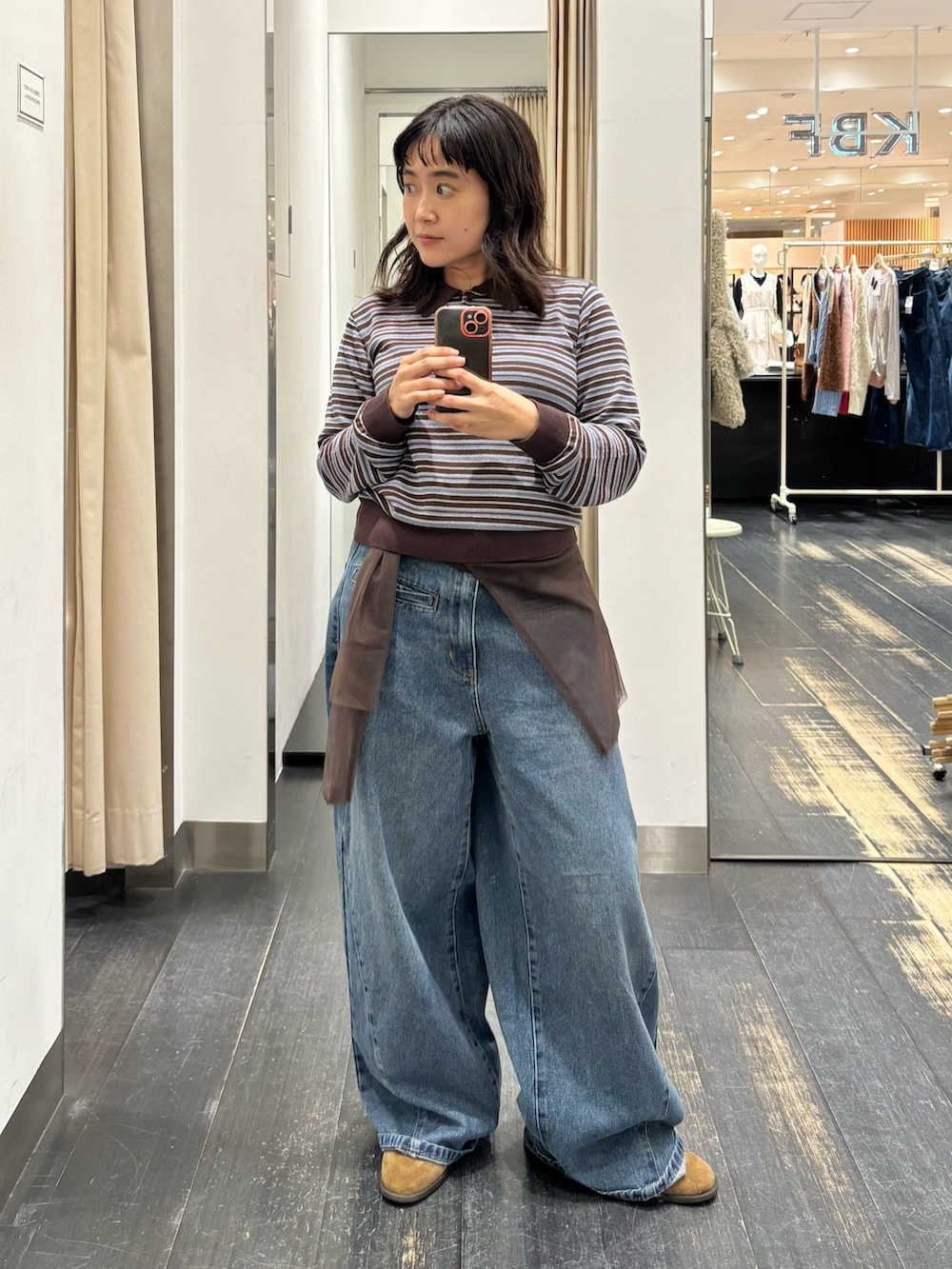 ブラウン系のニット/セーター、ブルー系のデニムパンツを着用したレディースの秋コーディネートの3枚目の写真