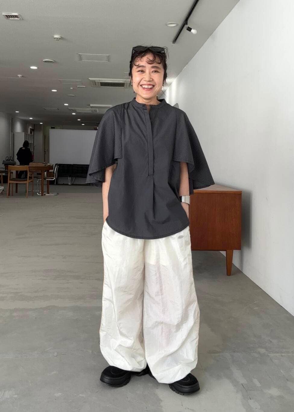 ホワイト系のその他パンツ、グレー系のシャツ/ブラウス、ブラック系のスニーカーを着用したレディースの夏コーディネートの3枚目の写真