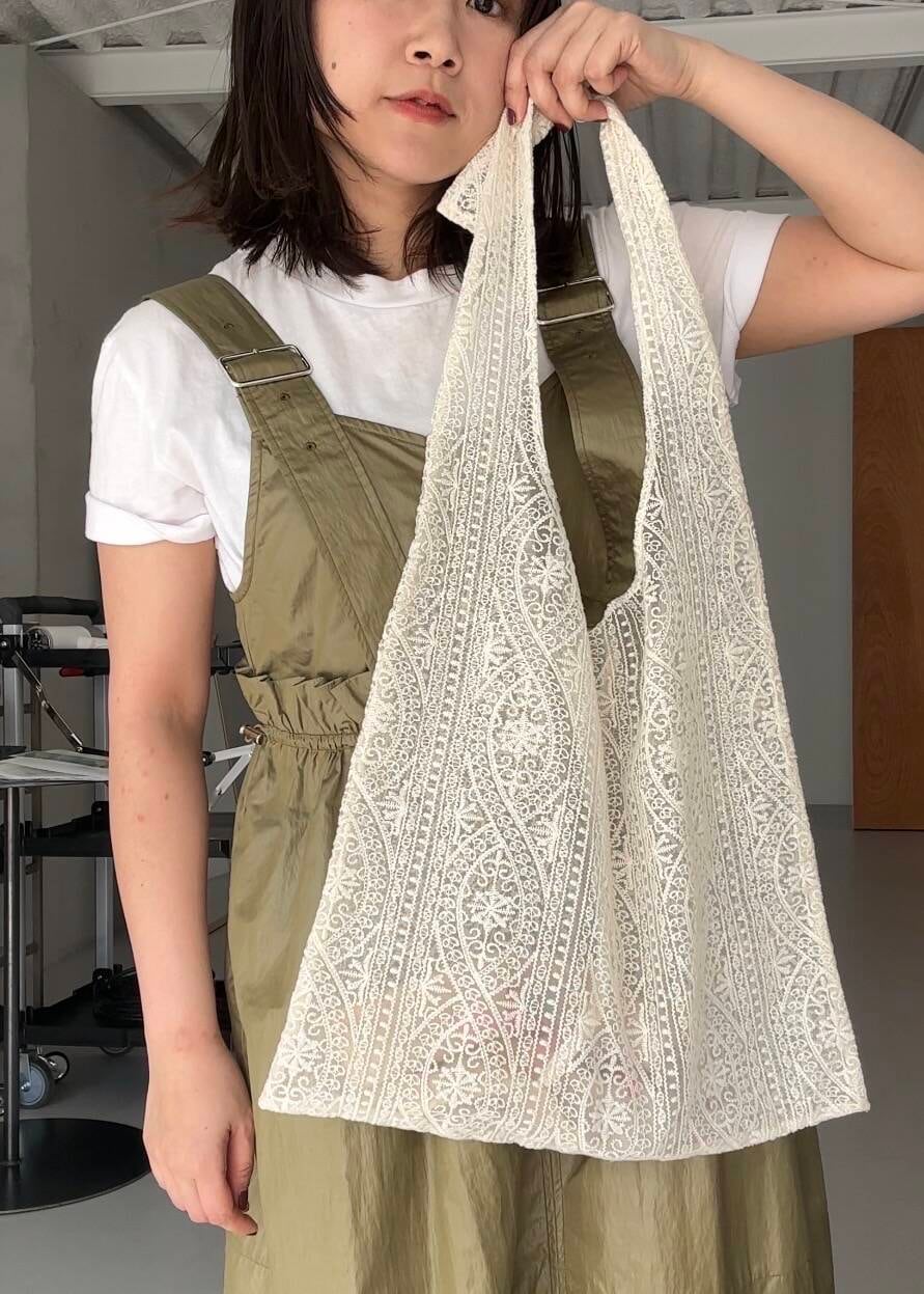 ブラック系のローファー、ホワイト系のショルダーバッグ、グリーン系のワンピースを着用したレディースの冬コーディネートの3枚目の写真