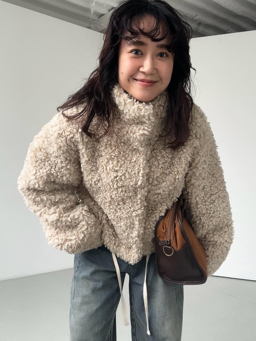 ホワイト系のその他アウター、ホワイト系のその他アウター、ベージュ系のボストンバッグを着用したレディースの秋コーディネートの2枚目の写真