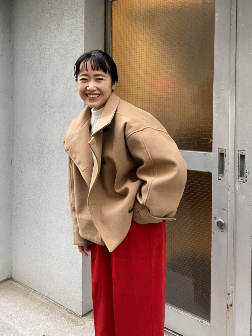 イエロー系のその他アウター、レッド系のその他パンツ、ベージュ系のブーツを着用したレディースの冬コーディネートの2枚目の写真