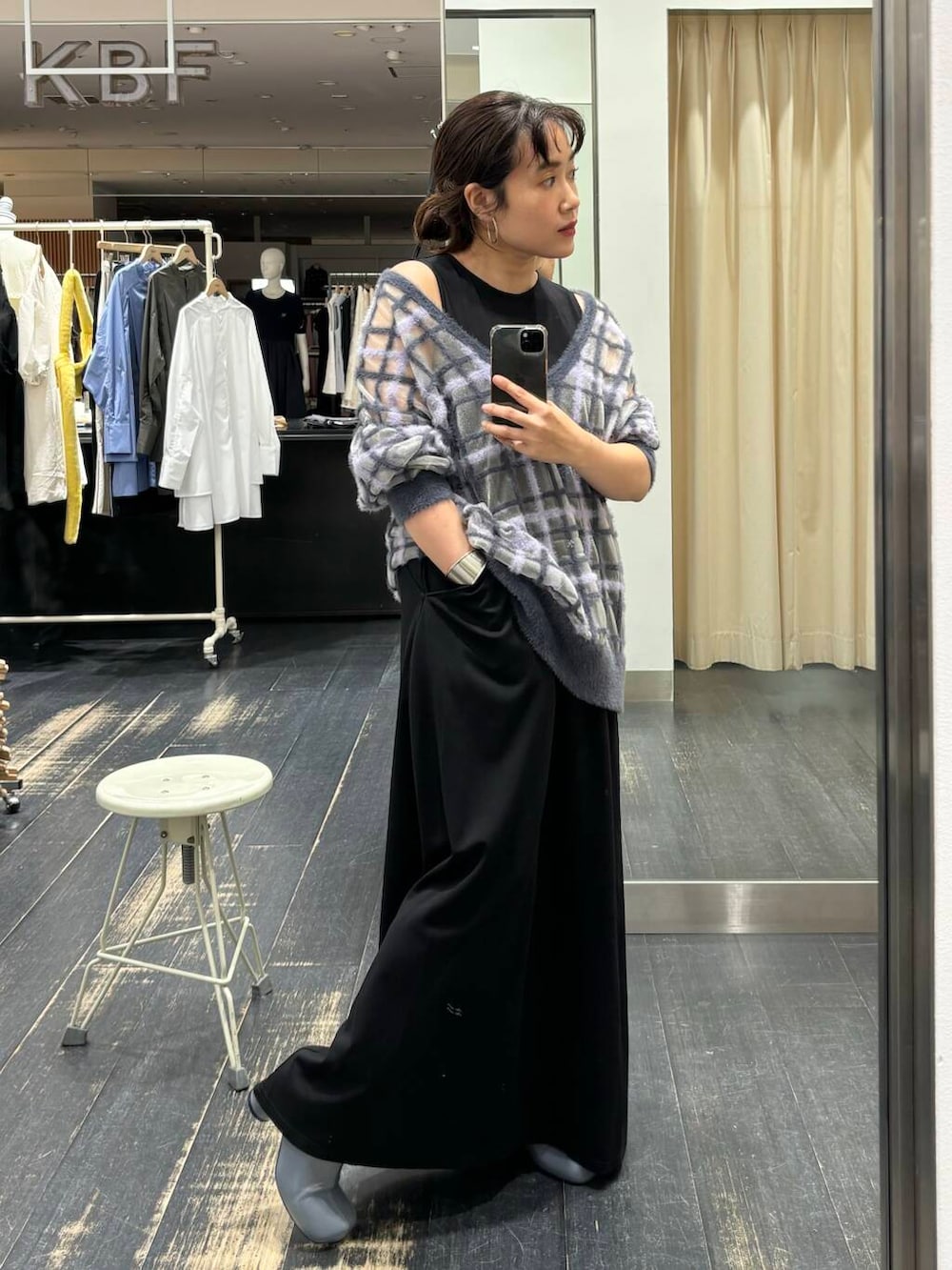 グレー系のニット/セーター、グレー系のブーツ、ブラック系のワンピースを着用したレディースの夏コーディネートの2枚目の写真