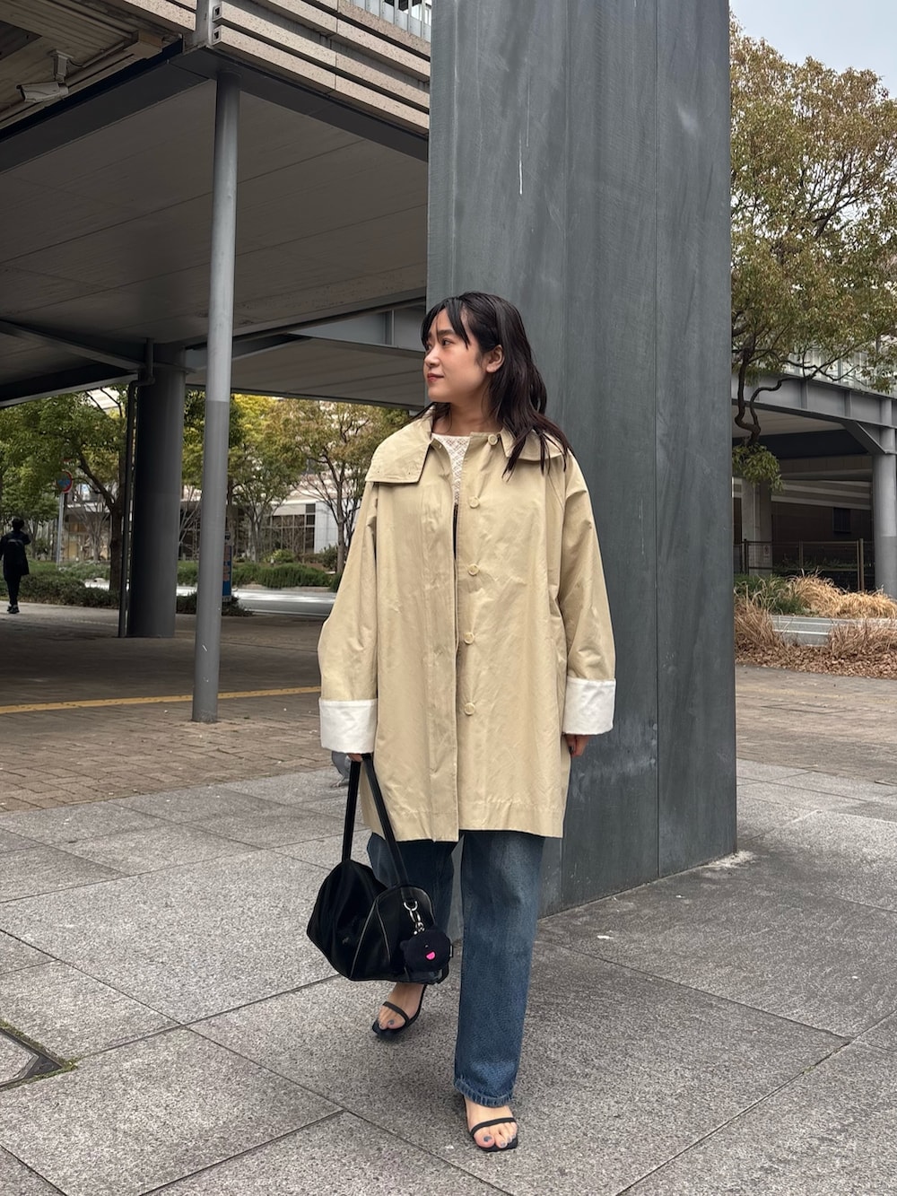 ブラック系のトートバッグ、ベージュ系のその他アウターを着用したレディースの春コーディネートの4枚目の写真