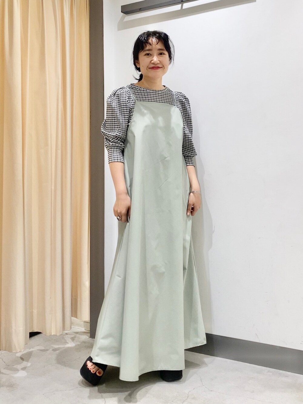 ブラック系のシャツ/ブラウス、グリーン系のワンピース、ブラック系のシューズを着用したレディースの春コーディネートの2枚目の写真