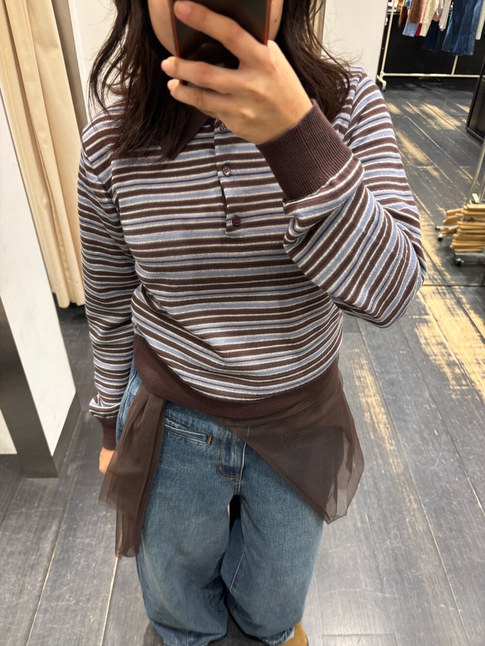 ブラウン系のニット/セーター、ブルー系のデニムパンツを着用したレディースの秋コーディネートの2枚目の写真