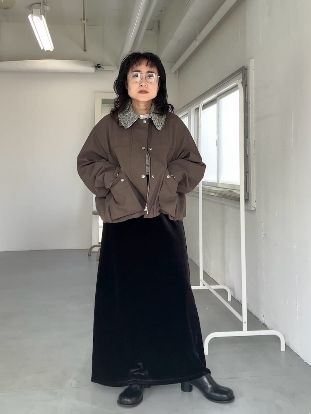 ブラウン系のブルゾン、ブラック系のスカート、ブラック系のスカートを着用したレディースの冬コーディネートの4枚目の写真