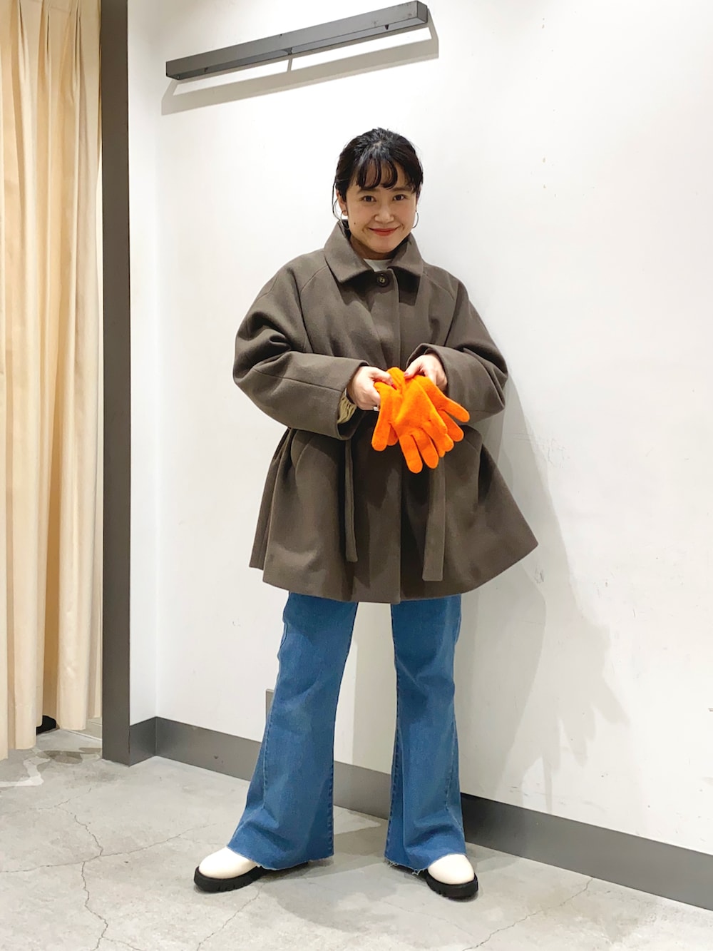 ブラウン系のピーコート、ホワイト系のブーツを着用したレディースの冬コーディネートの2枚目の写真