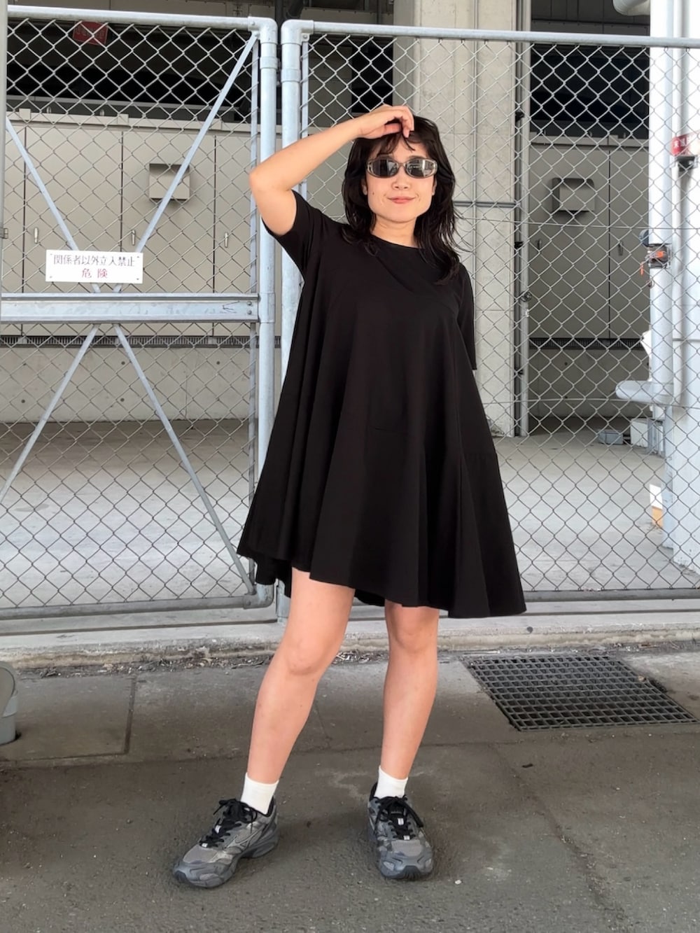 ブラック系のワンピースを着用したレディースの夏コーディネートの2枚目の写真