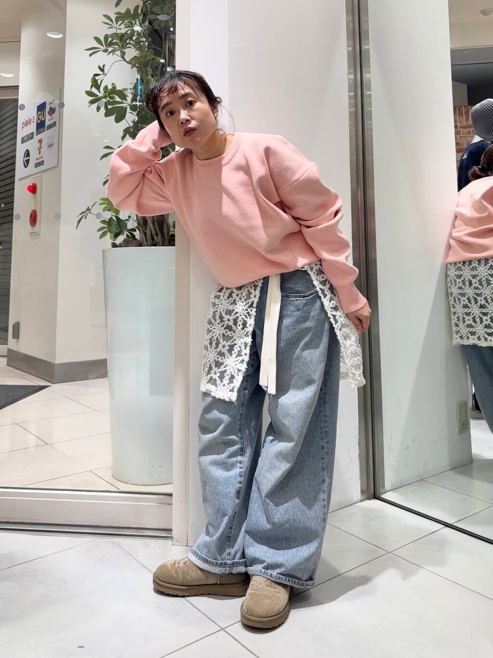 ブルー系のデニムパンツ、ホワイト系のスカート、ピンク系のニット/セーターを着用したレディースの冬コーディネートの2枚目の写真