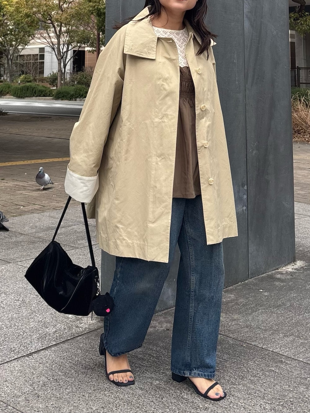 ブラック系のトートバッグ、ベージュ系のその他アウターを着用したレディースの春コーディネートの3枚目の写真