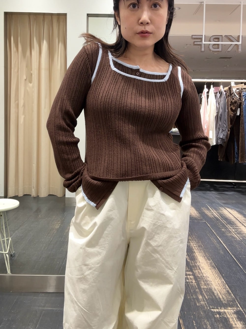 ブラウン系のニット/セーター、ホワイト系のその他パンツを着用したレディースの春コーディネートの2枚目の写真