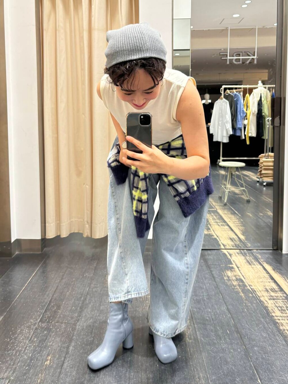 ブルー系のニット/セーター、ブルー系のデニムパンツ、グレー系のブーツを着用したレディースの夏コーディネートの2枚目の写真