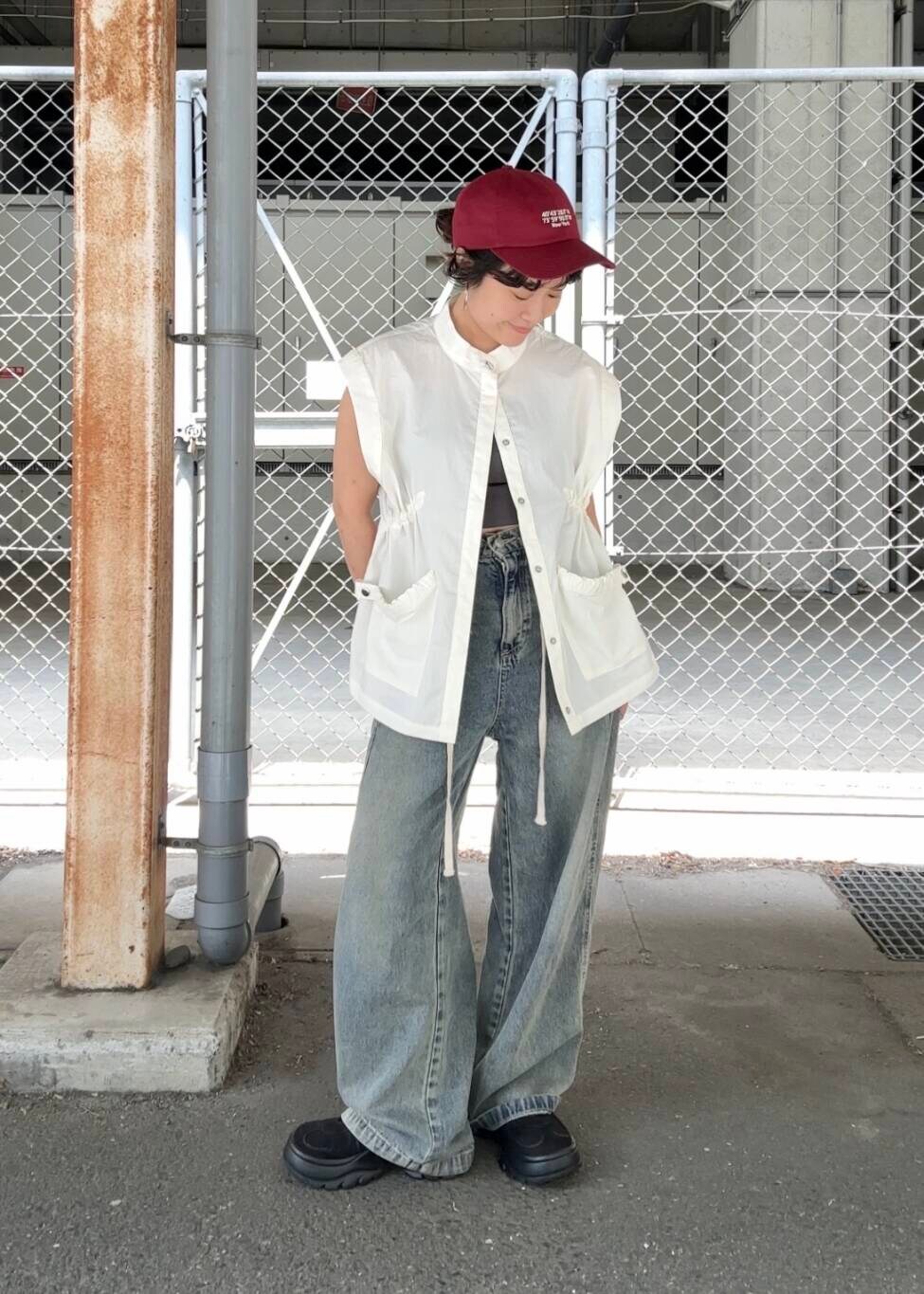 ブルー系のデニムパンツ、ブラック系のスニーカー、ホワイト系のその他アウターを着用したレディースの夏コーディネートの3枚目の写真