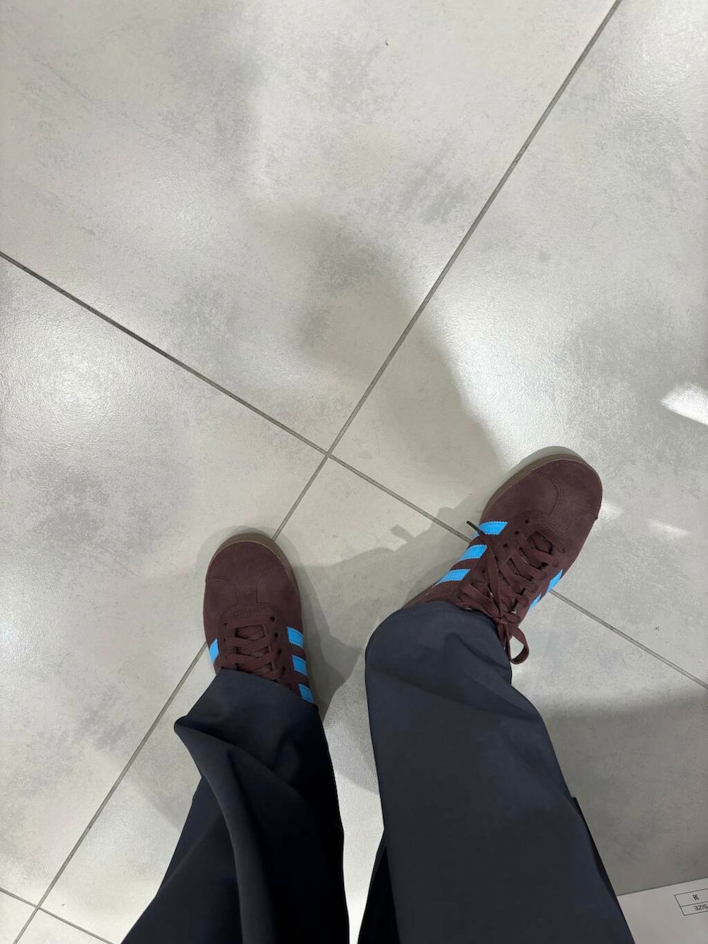 グレー系のその他パンツ、ホワイト系のシャツ/ブラウス、ブラウン系のスニーカーを着用したレディースの冬コーディネートの4枚目の写真