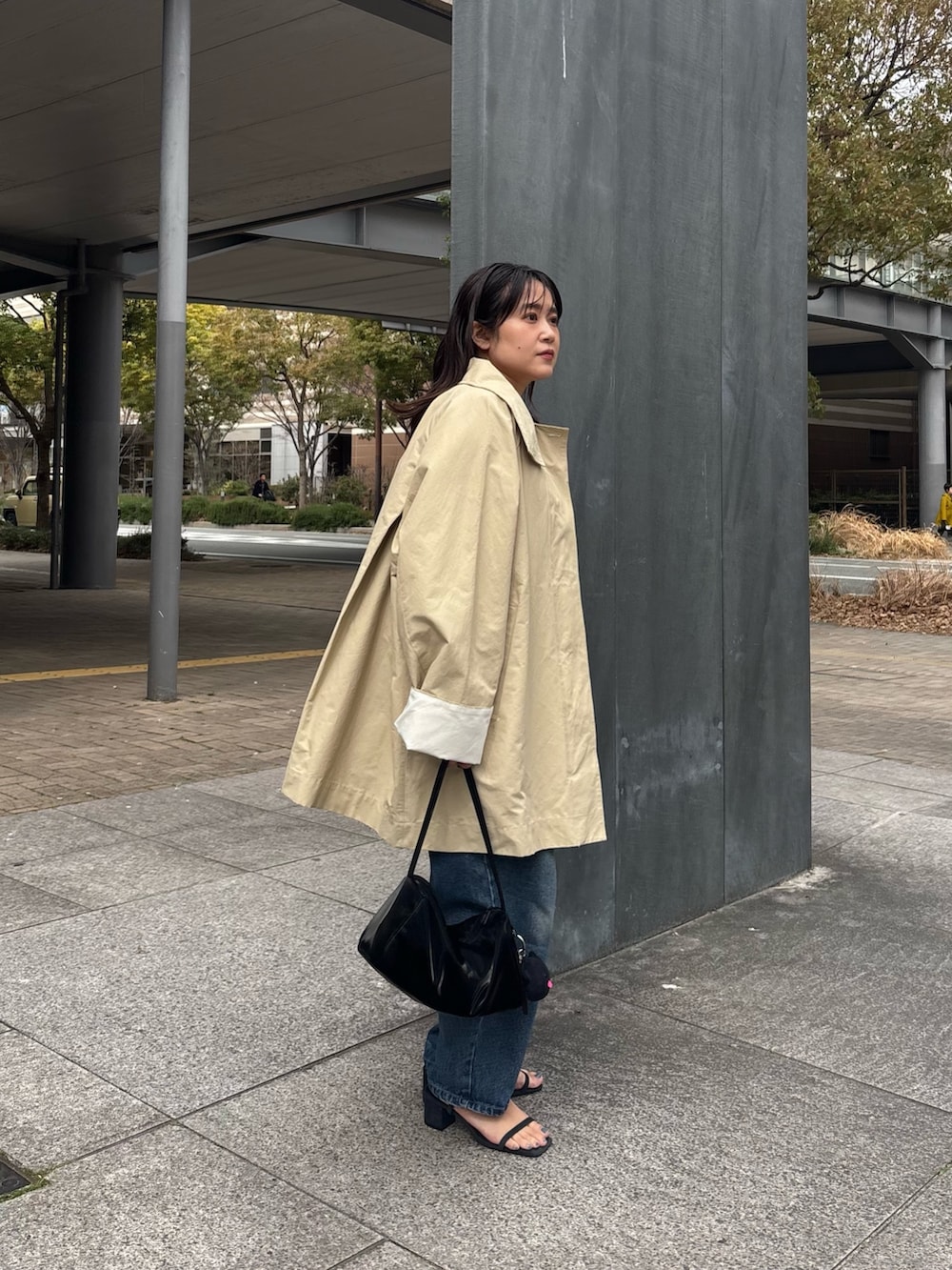 ブラック系のトートバッグ、ベージュ系のその他アウターを着用したレディースの春コーディネートの2枚目の写真